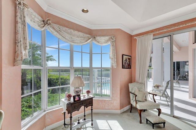 living area with ornamental molding and carpet