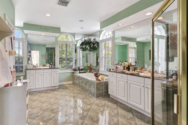 bathroom featuring vanity and separate shower and tub