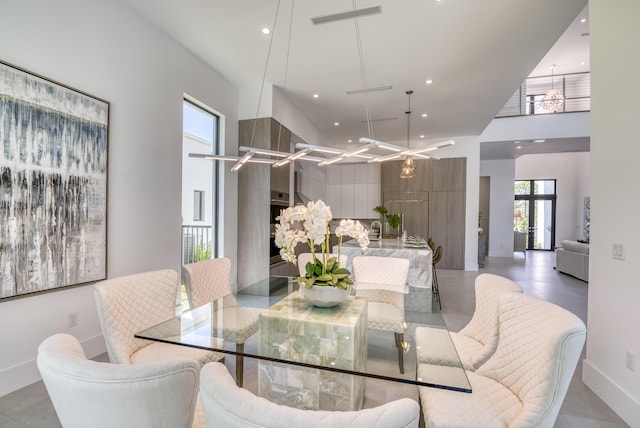 dining area featuring a high ceiling and a notable chandelier