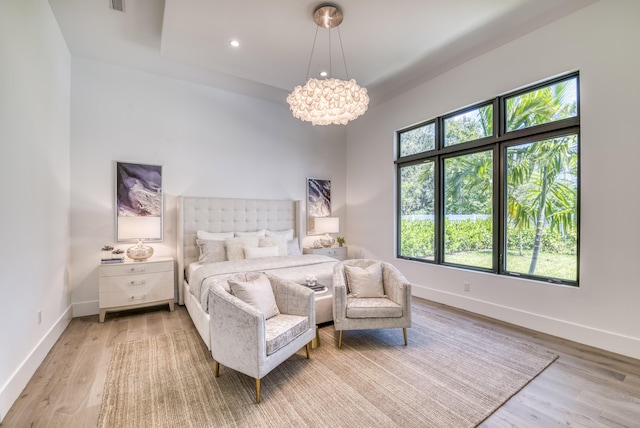 bedroom featuring an inviting chandelier and wood-type flooring