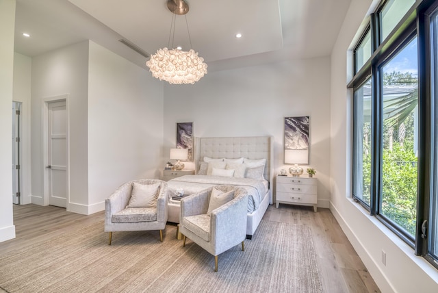 bedroom with an inviting chandelier and light hardwood / wood-style flooring