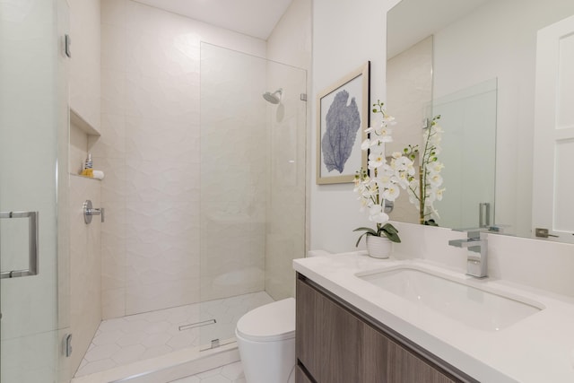 bathroom with vanity, a shower with door, and toilet