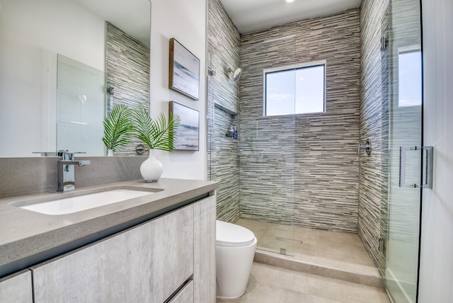 bathroom featuring vanity, toilet, and tiled shower