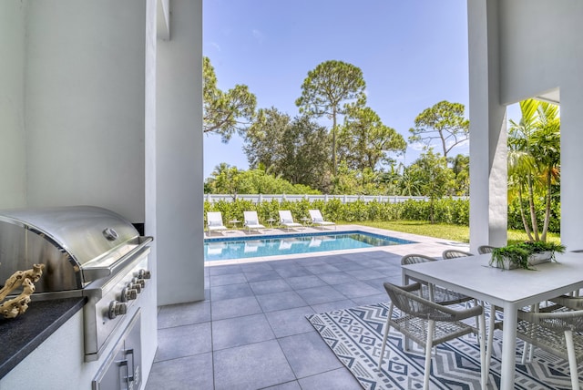 view of pool featuring area for grilling, exterior kitchen, and a patio area