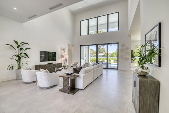 living room with light tile patterned floors and a high ceiling