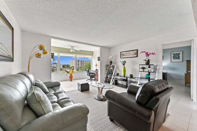 living room featuring light tile patterned floors, ceiling fan, and a textured ceiling