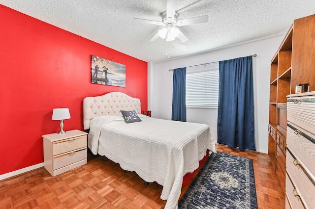 bedroom with a ceiling fan, baseboards, and a textured ceiling