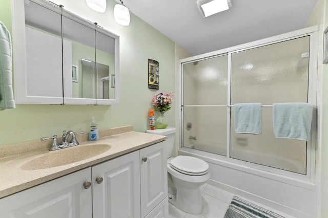 bathroom with enclosed tub / shower combo, vanity, tile patterned flooring, and toilet