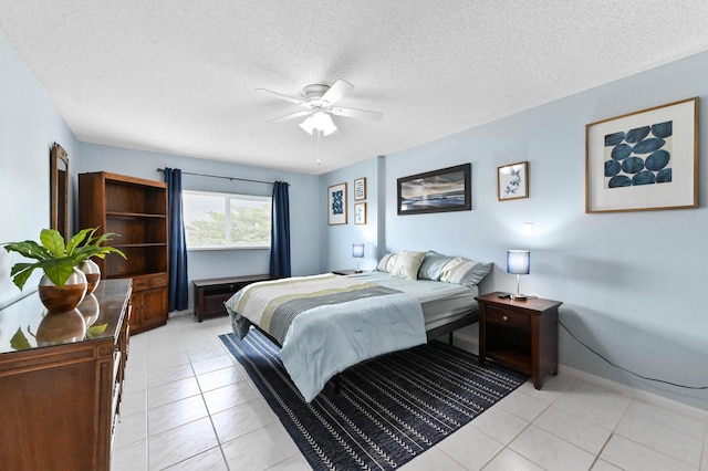 bedroom featuring light tile patterned floors, ceiling fan, a textured ceiling, and baseboards