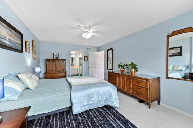 bedroom with light tile patterned floors, visible vents, ensuite bathroom, a textured ceiling, and baseboards