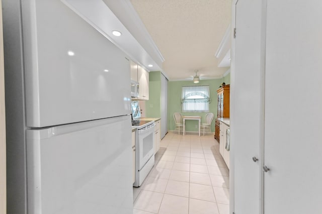 kitchen with light tile patterned floors, recessed lighting, white appliances, white cabinets, and light countertops