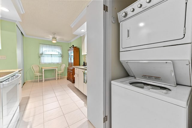 washroom with stacked washer and clothes dryer, crown molding, light tile patterned flooring, ceiling fan, and laundry area