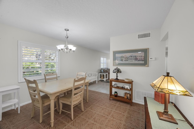 dining room with a textured ceiling and a chandelier