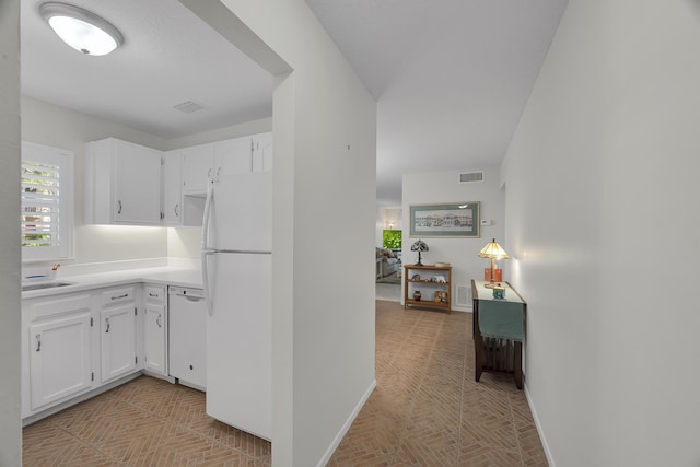 kitchen with sink, white cabinets, and white appliances