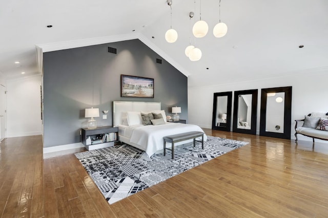 bedroom featuring lofted ceiling, crown molding, and hardwood / wood-style floors