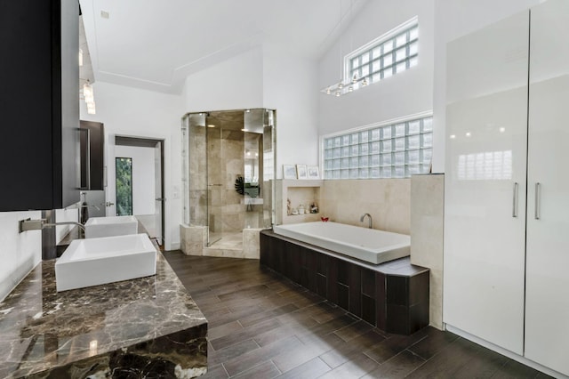 bathroom with a high ceiling, vanity, and independent shower and bath