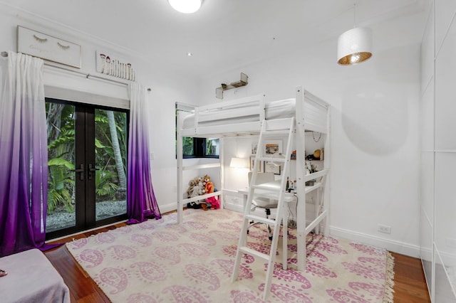 bedroom with wood-type flooring, french doors, and access to exterior