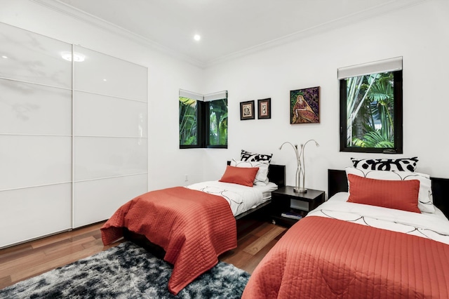 bedroom with crown molding and dark hardwood / wood-style floors