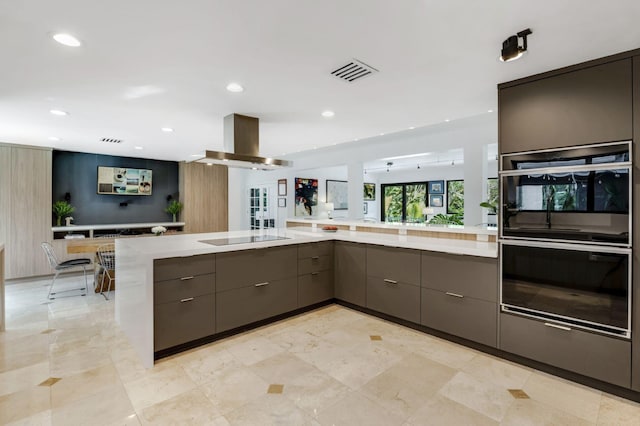 kitchen with kitchen peninsula, black appliances, gray cabinetry, and island range hood