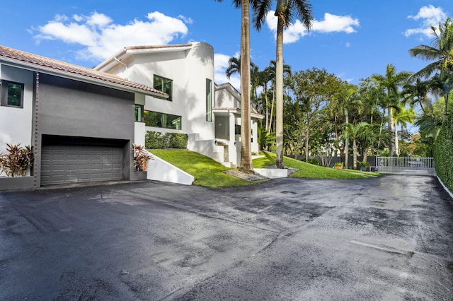 exterior space with a garage and a lawn