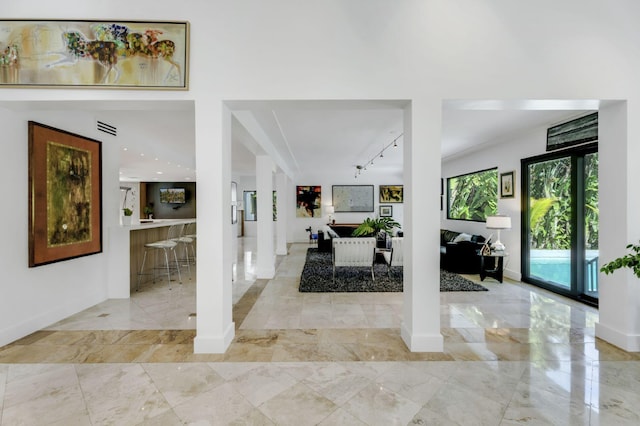 entryway with track lighting and decorative columns