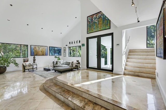 foyer entrance with french doors, high vaulted ceiling, and plenty of natural light