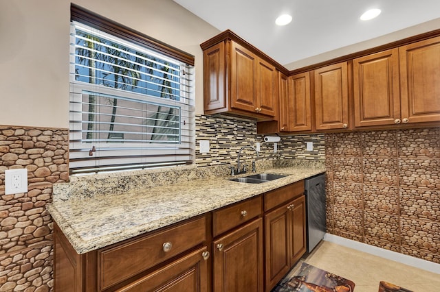 kitchen featuring tasteful backsplash, dishwasher, sink, and light stone counters