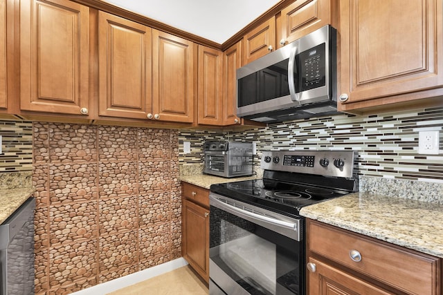 kitchen featuring light stone counters, appliances with stainless steel finishes, tasteful backsplash, and light tile patterned floors