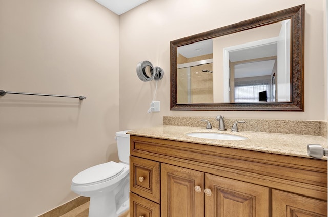 bathroom featuring vanity, an enclosed shower, and toilet