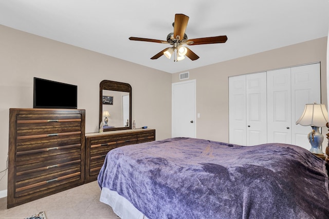 bedroom featuring light tile patterned floors, ceiling fan, and a closet