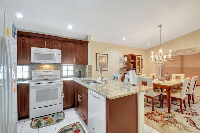 kitchen featuring sink, hanging light fixtures, kitchen peninsula, white appliances, and decorative backsplash