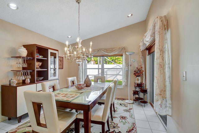 tiled dining area with lofted ceiling and an inviting chandelier