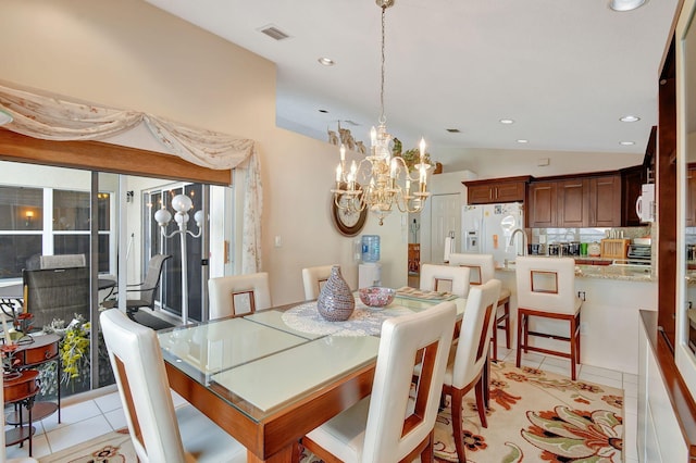 tiled dining room with vaulted ceiling and a notable chandelier