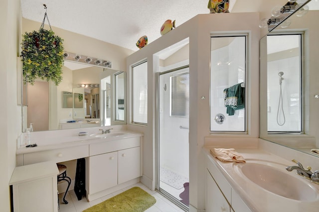 bathroom featuring vanity, tile patterned flooring, a textured ceiling, and a shower