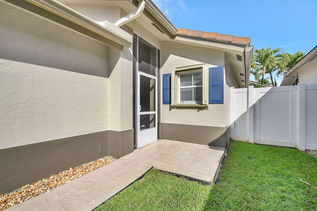 view of exterior entry with a lawn