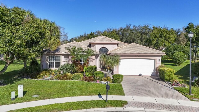 mediterranean / spanish home with a garage and a front yard