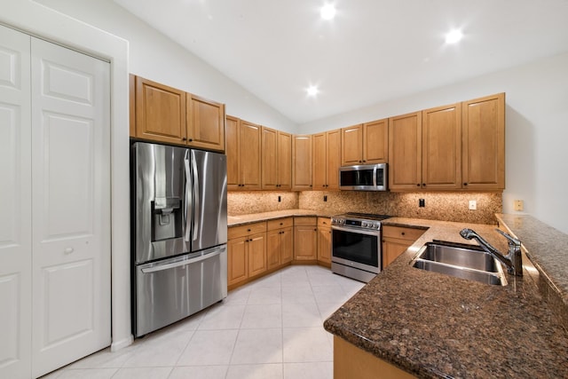kitchen featuring appliances with stainless steel finishes, sink, light tile patterned floors, and decorative backsplash