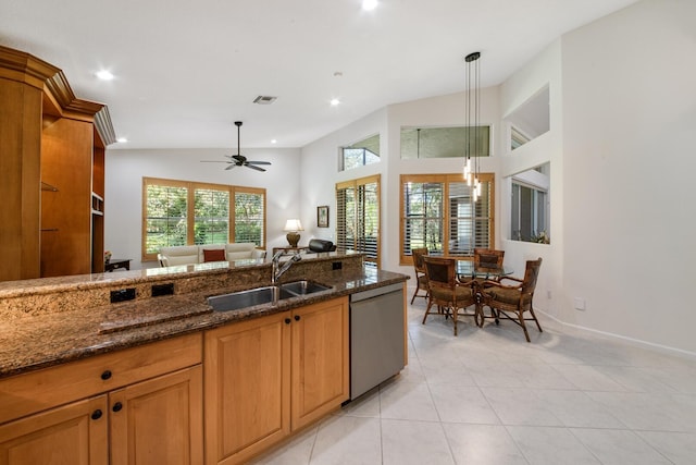kitchen featuring pendant lighting, sink, ceiling fan, dark stone countertops, and stainless steel dishwasher