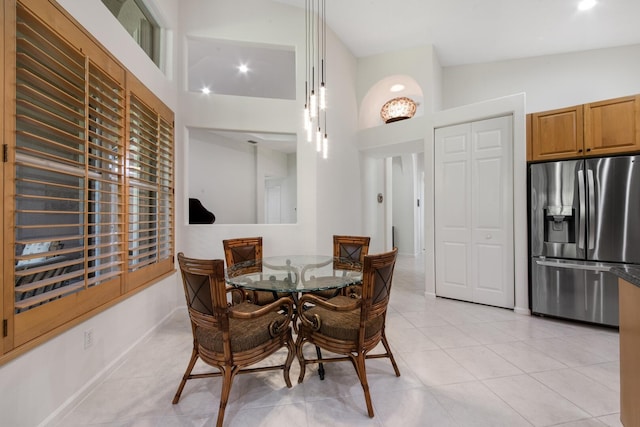 tiled dining room featuring high vaulted ceiling