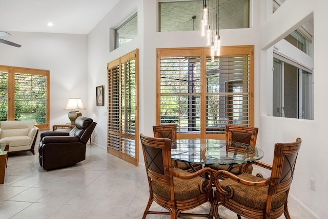 dining area with light tile patterned flooring and a towering ceiling