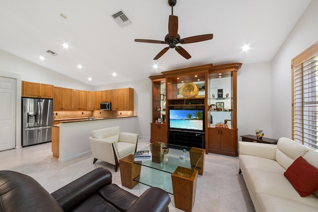 living room featuring vaulted ceiling, light tile patterned floors, and ceiling fan