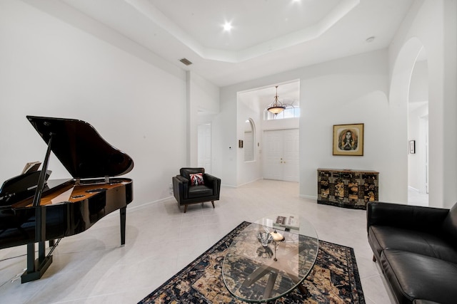 tiled living room featuring a raised ceiling