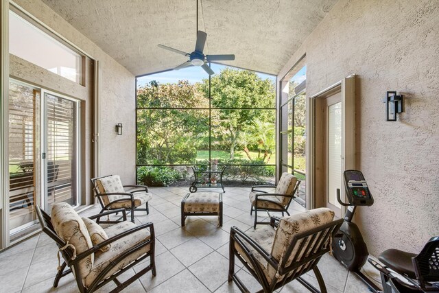 sunroom / solarium with ceiling fan, vaulted ceiling, and a wealth of natural light