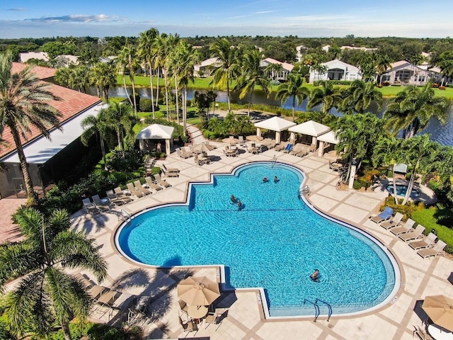 view of swimming pool with a water view and a patio area