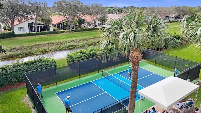view of sport court featuring a yard and a water view