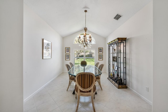 dining room with a notable chandelier, light tile patterned floors, and vaulted ceiling