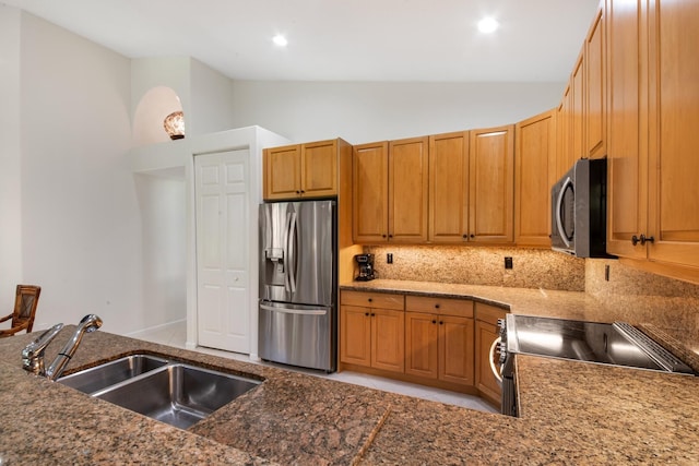 kitchen with vaulted ceiling, stainless steel appliances, sink, and decorative backsplash