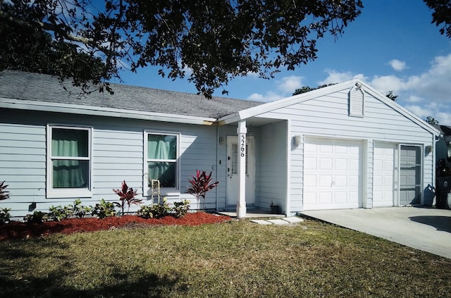 ranch-style home featuring a garage and a front lawn