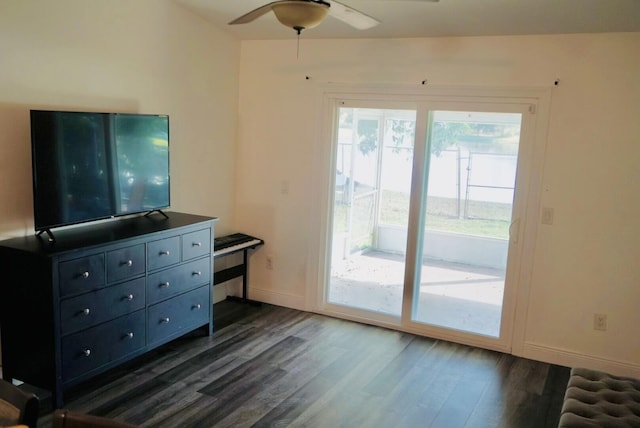 living room featuring dark wood-type flooring and ceiling fan