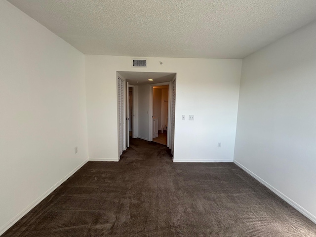 carpeted spare room with a textured ceiling